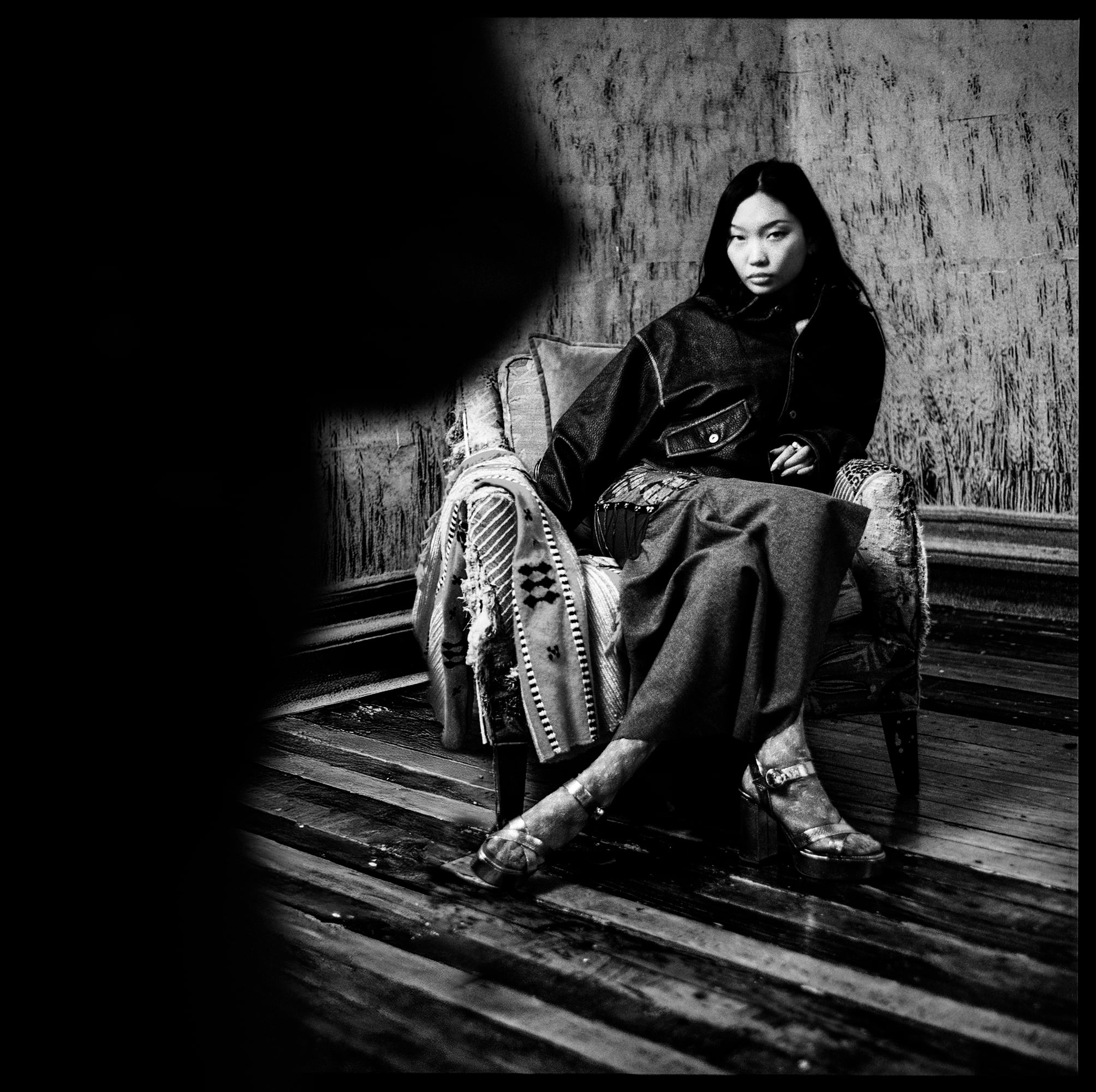 어두운 방의 등나무 의자에 앉은 여자, 흑백 사진